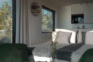 a bedroom with a bed with a table and a window at Exclusive off-grid tiny home at the beach - Kenshó 