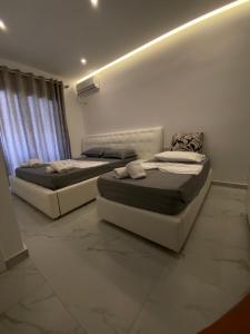 2 Betten in einem Zimmer mit einer Wand in der Unterkunft Villa Mucodemi 1 in Ksamil