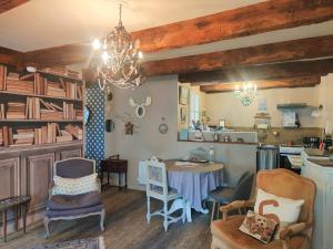 a living room with a table and chairs and a chandelier at Ty Brigitte in Dinan