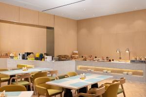 a restaurant with tables and chairs and a counter at Home2 Suites by Hilton Beijing West Station in Beijing
