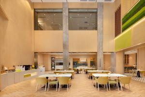 a dining area with tables and chairs in a cafeteria at Home2 Suites by Hilton Beijing West Station in Beijing