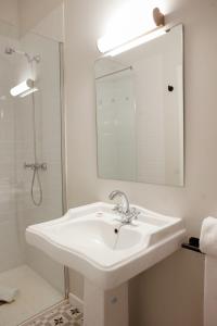 bagno bianco con lavandino e specchio di Casa Alberola Apartments ad Alicante