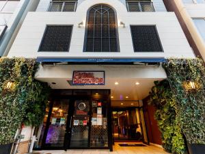 un magasin à l'avant d'un bâtiment muni d'un panneau. dans l'établissement Hotel La Foresta By Rigna, à Fukuoka
