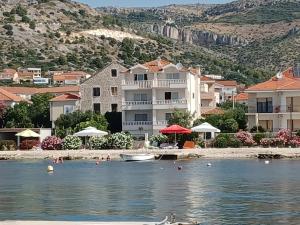 a group of houses on the shore of a body of water at Apartments Amor in Trogir