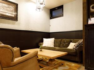 un soggiorno con divano, tavolo e sedie di Hotel La Foresta By Rigna a Fukuoka