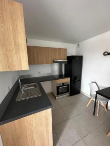 パラヴァ・レ・フロにあるCoeur de ville appartement 4 personnes avec vue mer N2 142のキッチン(シンク、黒い冷蔵庫付)