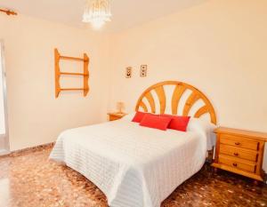グラナダにあるApartamento Jose Enriqueのベッドルーム(赤い枕の大きな白いベッド付)