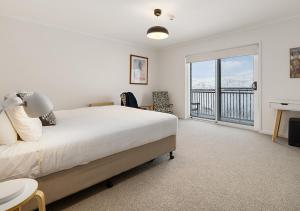 a bedroom with a bed and a balcony at Guthega Inn in Perisher Valley
