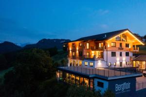 una imagen de una casa por la noche con luces en Hotel Bergflair en Fischen