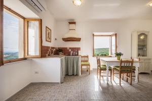 a kitchen and dining room with a table and chairs at La sosta del pellegrino in Sorano