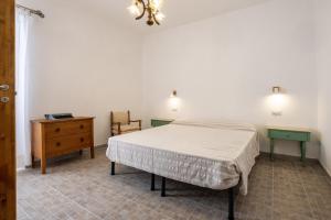 a bedroom with a bed and a dresser and lights at La sosta del pellegrino in Sorano