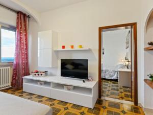 un soggiorno con TV e armadio bianco di Pleasant Apartment with Courtyard a Saludecio