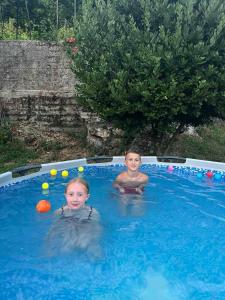 two children in a swimming pool with balls in it at Auto camp Radoman in Virpazar