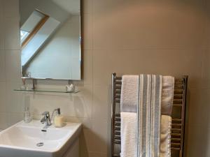 a bathroom with a sink and a mirror and a towel at Self Contained Studio Rumbling Bridge in Kinross