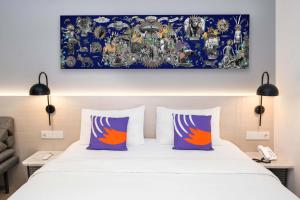 沙马林达FOX Lite Hotel Samarinda的床上有两张枕头,上面有画
