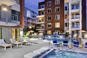 a patio with a swimming pool and chairs and a building at Little Italy 1br w gym bbq pool nr light rail SAN-5 in San Diego