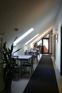 a dining room with tables and chairs and a plant at Megacentrum Szállás in Szekszárd