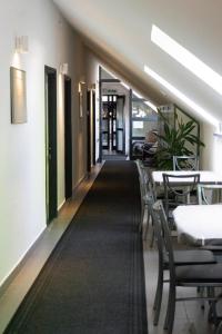 a corridor of a restaurant with tables and chairs at Megacentrum Szállás in Szekszárd