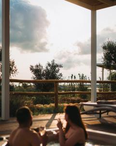 Ein Mann und eine Frau sitzen in einem Whirlpool auf einer Terrasse in der Unterkunft Methe in Lizzano