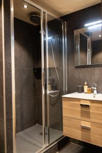 uma casa de banho com um chuveiro e um lavatório. em IMMODREAMS - La Cabane em Morzine