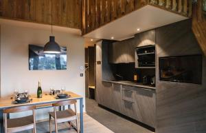 uma cozinha com um balcão e uma mesa com cadeiras em IMMODREAMS - La Cabane em Morzine