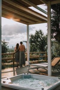 Ein Mann und eine Frau stehen auf einer Terrasse mit Whirlpool in der Unterkunft Methe in Lizzano