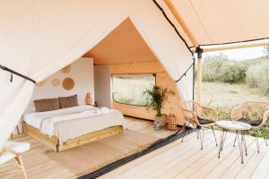 1 dormitorio en una tienda de campaña con 1 cama y sillas en Dreamsea Surf Guest House en Sintra