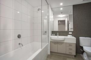 a bathroom with a sink, toilet and bathtub at Hudson Parap in Darwin