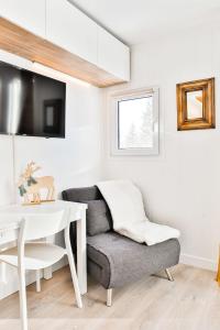 Una sala de estar con una silla y una mesa. en IMMODREAMS - Le Vivace, en Avoriaz