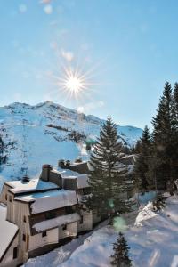 un edificio en la nieve con el sol en el cielo en IMMODREAMS - Le Vivace, en Avoriaz