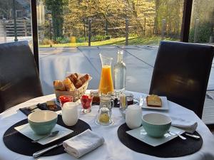 - une table avec petit-déjeuner composé de pain et de jus d'orange dans l'établissement Guestroom Épinal, 1 pièce, 2 personnes - FR-1-589-473, à Épinal