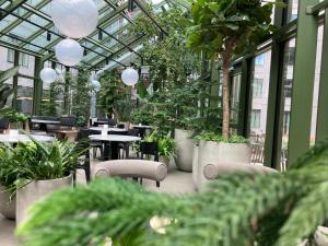 a greenhouse with tables and chairs and potted plants at UNITY Malmö in Malmö
