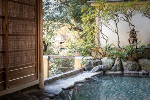 a swimming pool in a garden next to a house at Senkei Plaza in Hakone