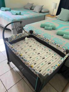 two twin beds sitting in a room with at Tavake Home Moorea in Papeete