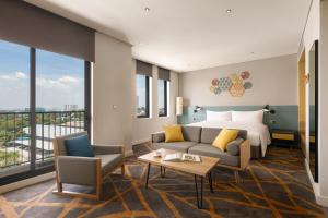 a hotel room with a bed and a couch at HIIVE by fusion Binh Duong - VSIP 1 in Thuan An +10 photos
