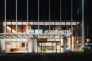 重慶市にあるAtour Hotel Chongqing Liangjiang District Jinke Centerのホテルの案内を読む看板のある建物