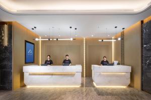 three people sitting at a counter in a waiting room at Atour X Hotel Yanji Department Store West Market in Yanji