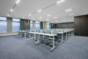 einen Konferenzraum mit langen Tischen und Stühlen in der Unterkunft Atour S Hotel Lanzhou Asia-Europe International High Altitude in Lanzhou