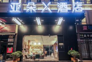 una tienda con un cartel en la parte delantera de un edificio en Atour X Hotel Chuxiong Yihai Park, en Chuxiong
