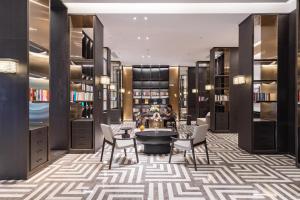 a library with a table and chairs and bookshelves at Atour Hotel Guangzhou Panyu Jewelry City in Guangzhou