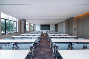 an empty classroom with rows of desks and a screen at Atour Hotel Shanwei High-Speed Railway Station Binhai Park in Shanwei