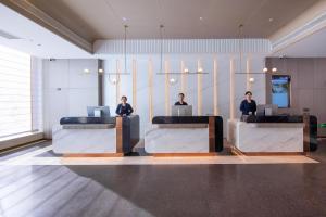 three people sitting at desks in a lobby at Atour S Hotel Yinchuan Drum Tower North Yuhuangge Street in Yinchuan