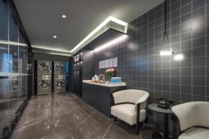 La salle de bains est pourvue d'un lavabo et de 2 chaises. dans l'établissement Atour Hotel Taizhou Linhai Toumen Port, à Linhai