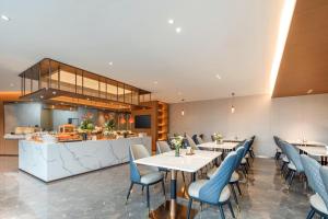 Un restaurante con mesas y sillas y un mostrador. en Atour Hotel Tonglu City Center Hangzhou, en Xiaoba