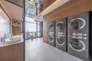 eine Waschküche mit vier Waschmaschinen und einem Waschbecken in der Unterkunft Atour Hotel Xiapu Fujian in Fuzhou