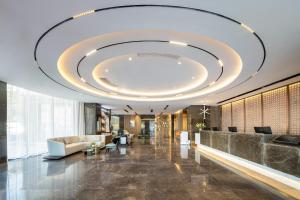 a large lobby with a large ceiling at Atour Hotel Xinghua Dainan in Xinghua