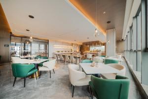 重慶的住宿－重庆两江新区金科中心亚朵酒店，餐厅设有白色的桌子和绿色的椅子