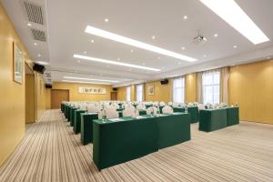 une salle de conférence avec des tables vertes et des chaises blanches dans l'établissement Atour X Hotel Wuxi Binhu Sports Center, à Wuxi