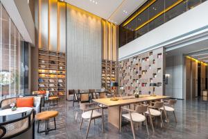 a restaurant with a table and chairs and wine racks at Atour Hotel Dali Erhai Park in Dali