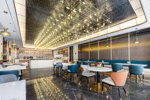 a restaurant with tables and chairs and a bar at Atour Hotel Kunshan Chengdong Development Zone in Kunshan